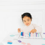 Little girl playing with Montessori inspired mini domino map toy. 