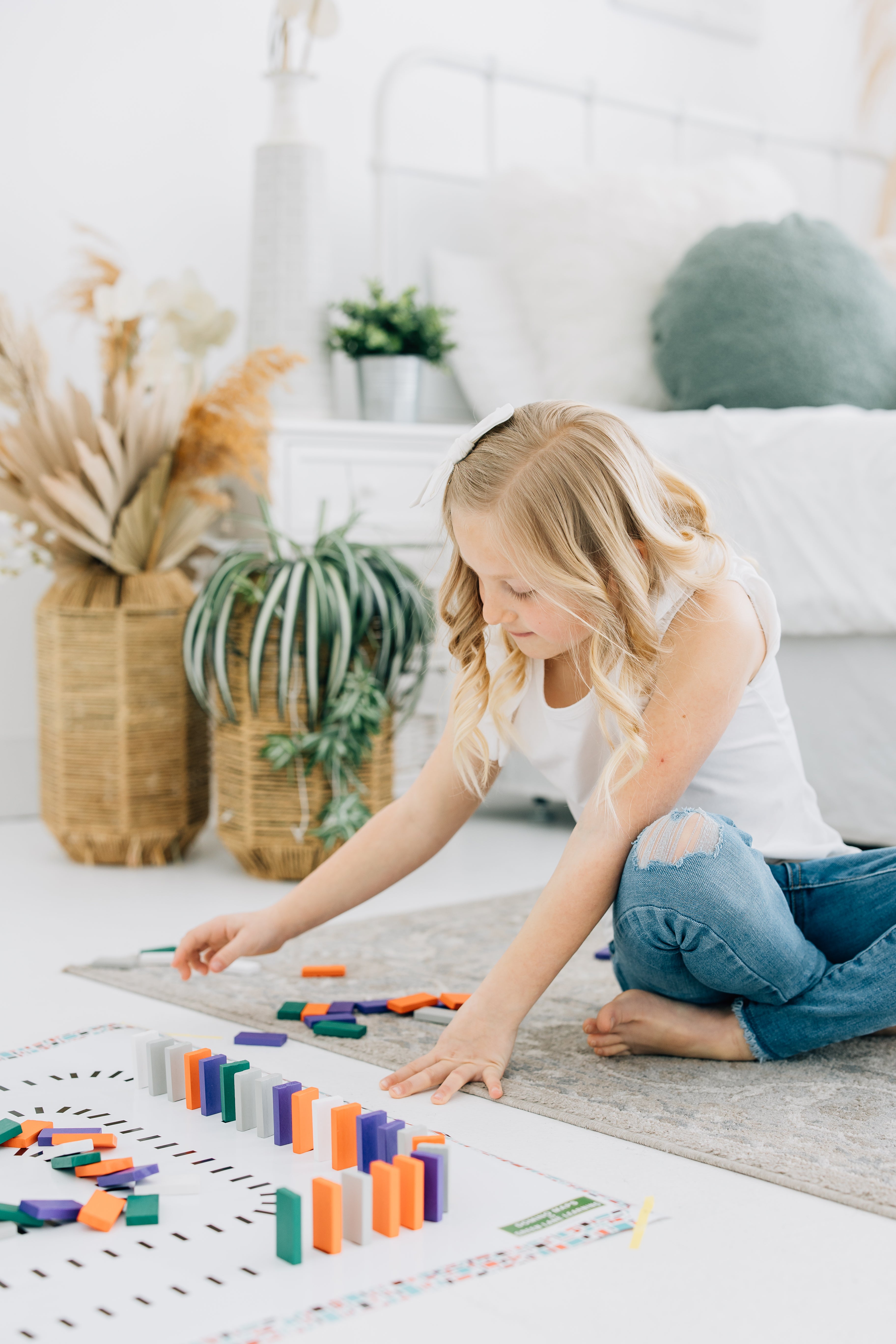 Little girl using wooden dominoes for open ended play. 