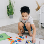 Little boy playing with mini domino maps for a STEM activity.
